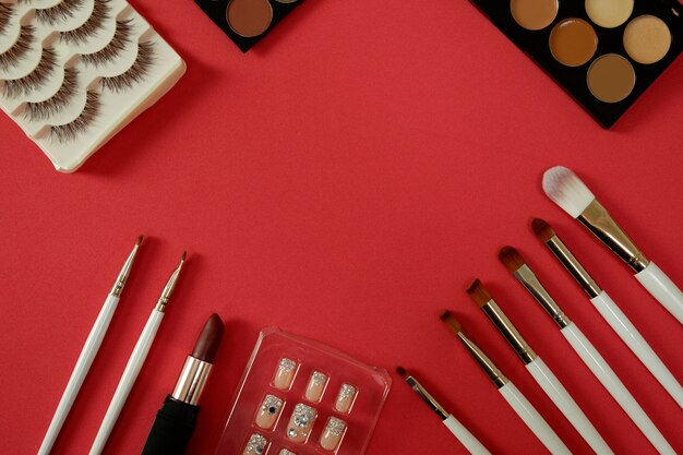 Top view of womenâs cosmetic on red background.