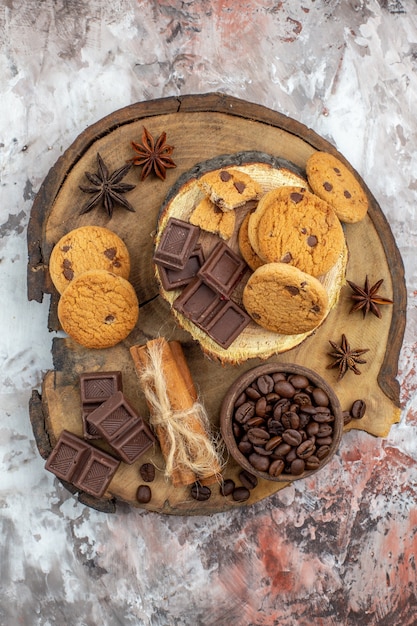 top view wood rustic board with cookies bowl with roasted coffee beans chocolate cocoa bowl cinnamon sticks on table