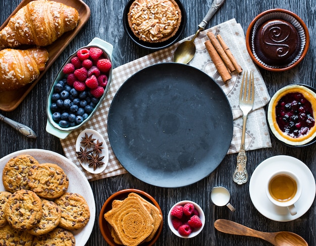 케이크, 과일, 커피, 비스킷, 향신료 등으로 가득 찬 나무 테이블의 평면도