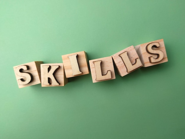 Top view wooden block and word with word skills on green\
background