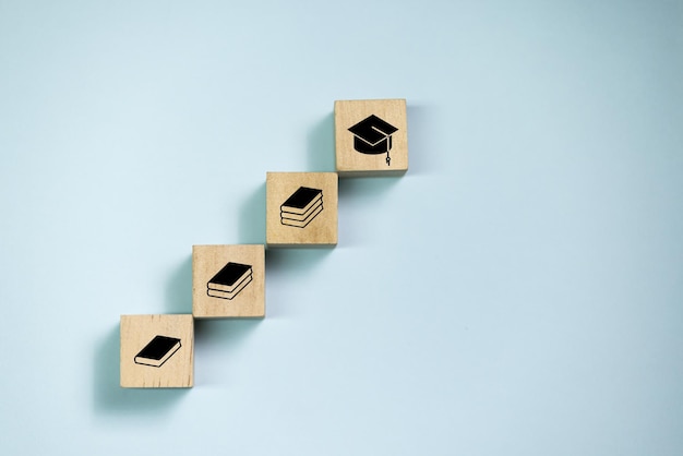 Foto blocchi di legno con vista dall'alto impostati per passare con l'icona del libro per l'icona del diploma concetto per l'apprendimento e l'istruzione