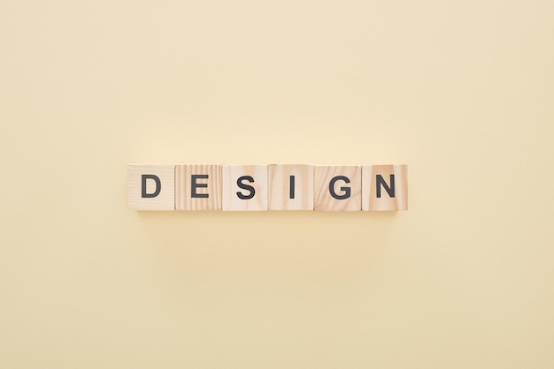 Photo top view of wooden blocks with design lettering on beige background