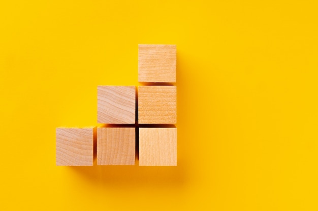 Top view of wooden cubes on yellow background