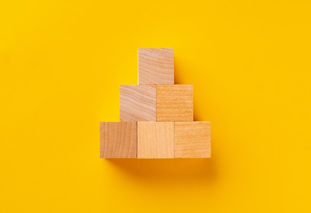 Top view of wooden cubes on yellow background