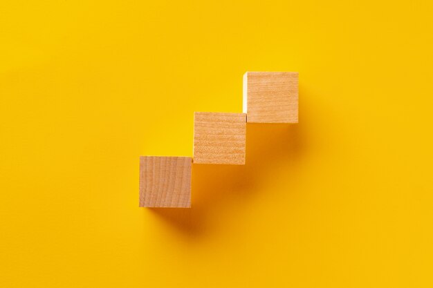 Top view of wooden cubes on yellow background