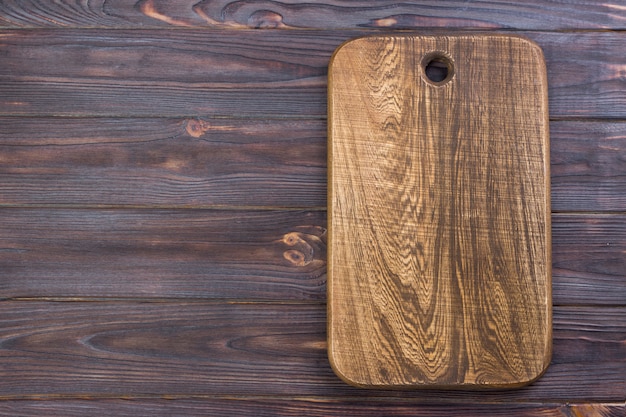 Top view of wooden cutting board on old wooden table