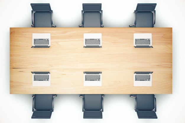 Photo top view of wooden meeting table with chairs and laptop