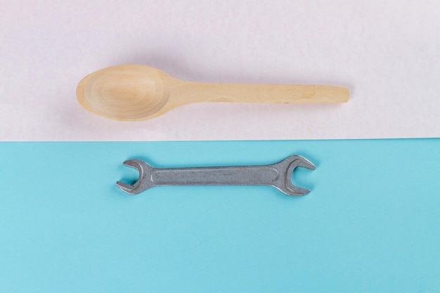 Top view wooden rustic spoon and metallic wrench concept of separation of duties between man and wom
