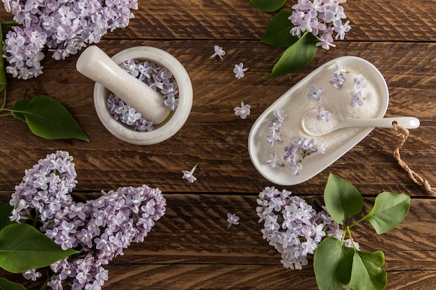 Top view of the wooden rustic table with lilac branches and sugar from flowers in different containers aromatic sugar to improve the taste of tea