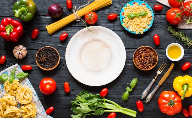 Top view of a wooden table full of italian pasta ingradients