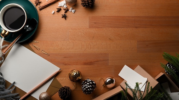 Top view of wooden table with coffee cup supplies and decorations in Christmas concept