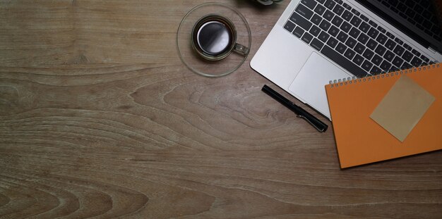 Top view of workplace with laptop computer with coffee cup and notebook 