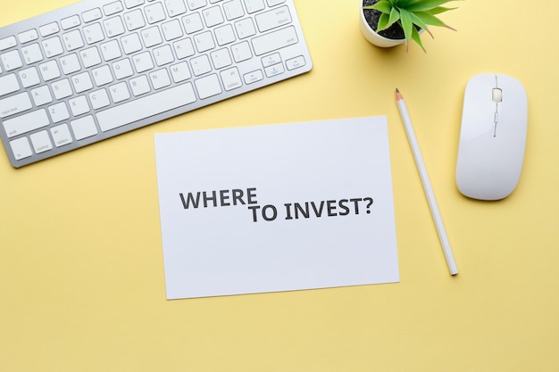 Top view on workplace with question where to invest