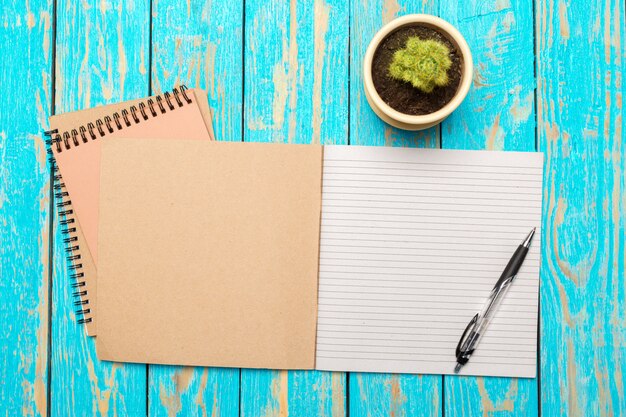 Photo top view workspace with blank notebook and pen on wooden table background