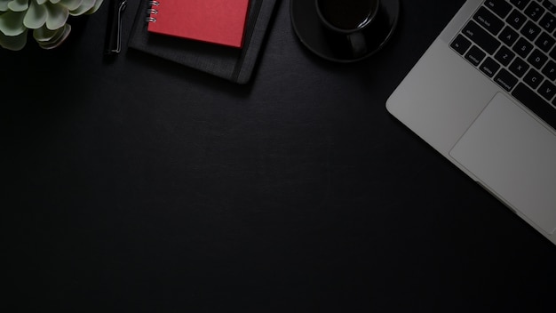 Top view of workspace with laptop computer, notebooks, coffee cup and copy space