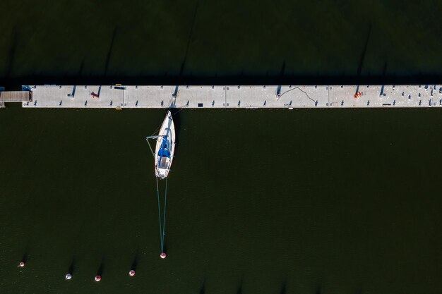 Top view of the yacht in the dock on a dark water\
background