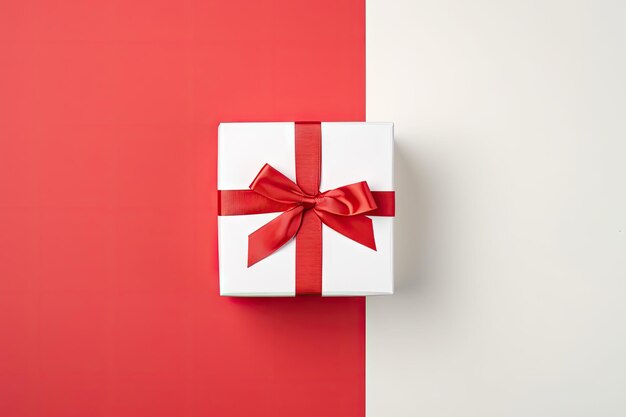 Top view of yellow background with white gift box and red ribbon