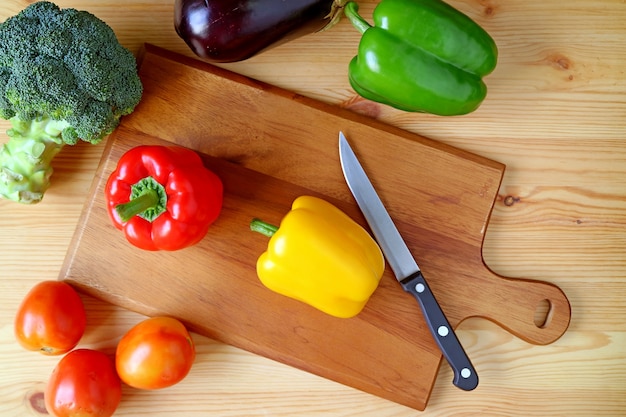 Top View of Yellow Bell Pepper on Cutting Board with Knife and Another Vegetables