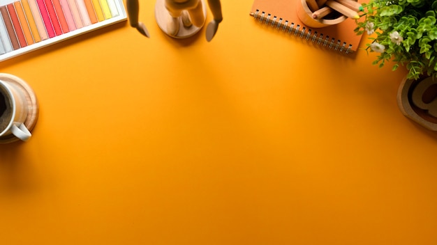 Top view of yellow creative flat lay workspace with coloured pencils decorations and copy space