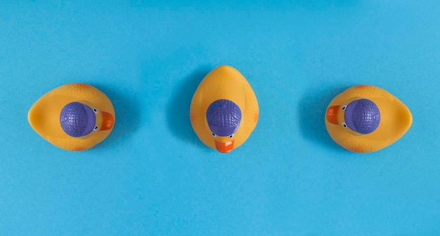 Top view of yellow toy duckling for bathing on the blue background Copy space Closeup