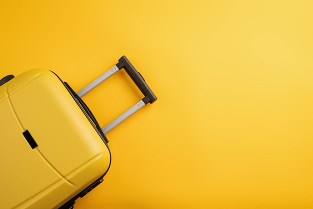 Top view yellow travel bag or suitcase on solid yellow background copy space tourist essentials