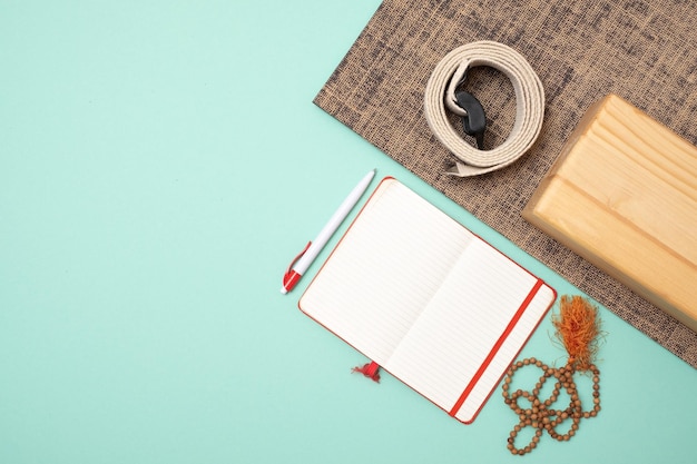 Vista dall'alto degli accessori per lo yoga e del taccuino per la scrittura del corso di insegnamento dello yoga