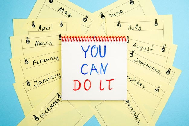 top view you can do it written on spiral notebook monthly reminder cards on blue table