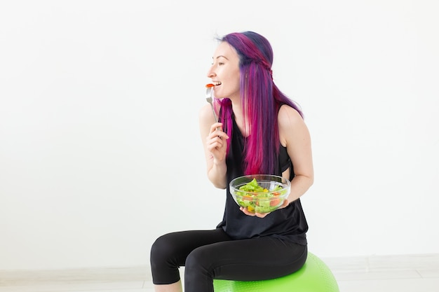 그녀의 집에서 운동 후 가벼운 야채 샐러드를 먹는 젊은 아시아 hipster 소녀의 최고 볼 수 있습니다. 체중 감량과 건강한 라이프 스타일의 개념