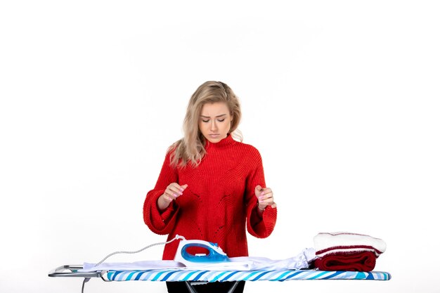 Top view of young beautiful woman looking at iron and clothes on white background