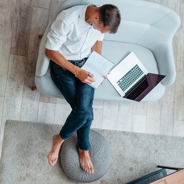 Top view. young businessman making notes in a notebook. domestic life.