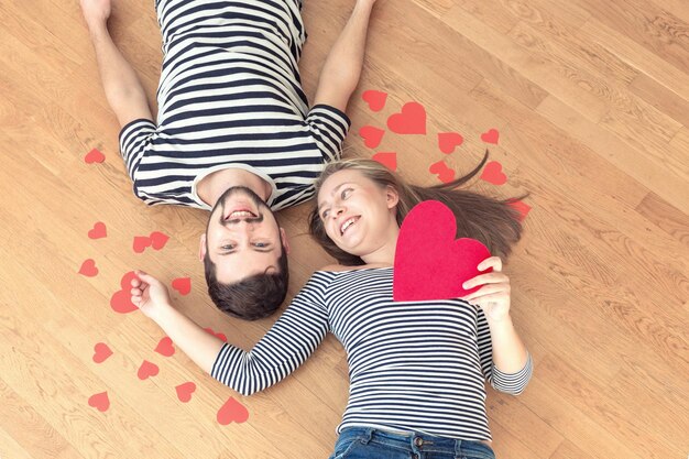 Top view young couple lying on the floor and looking to camera and smile