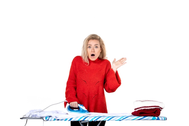 Photo top view of young and curious beautiful woman ironing clothers on white background