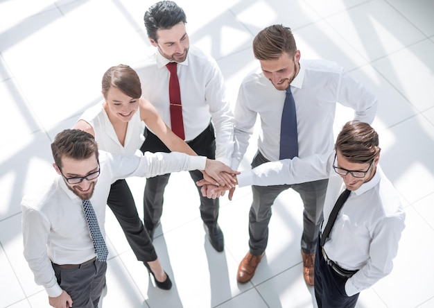 Top view young employees folding their hands together