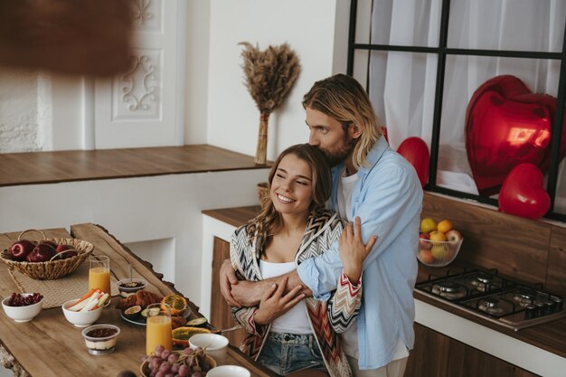 Foto vista dall'alto di una giovane coppia di innamorati che si abbraccia mentre festeggia san valentino nella cucina domestica