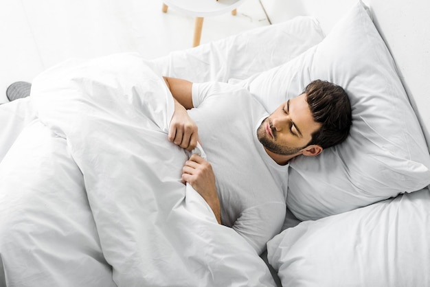 Premium Photo | Top view of young man sleeping in bed in the morning