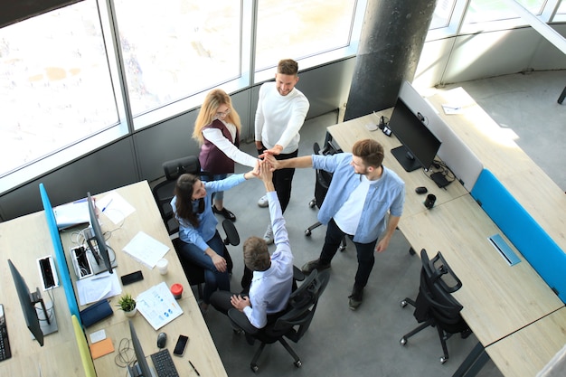 Foto vista dall'alto di giovani colleghi moderni in abbigliamento casual intelligente che lavorano insieme mentre trascorrono del tempo in ufficio.