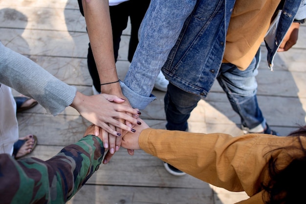 Top view of young people putting their hands together outdoor Friends with stack of hands showing u