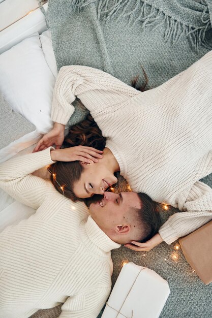 Top view of young romantic couple that lying down and celebrates New year together indoors