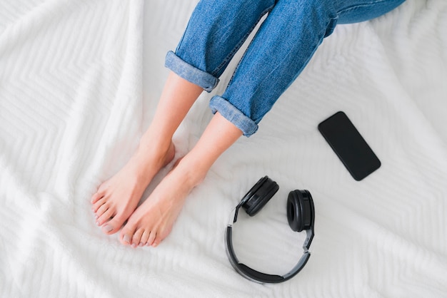 写真 トップビューの若い女性の足とデジタルデバイス