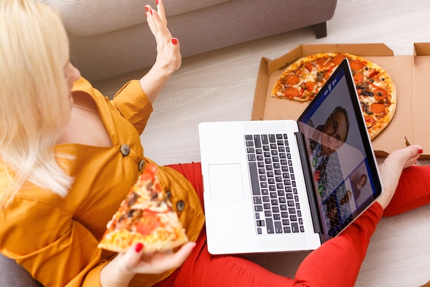 Top view of young woman sitting on floor with laptop