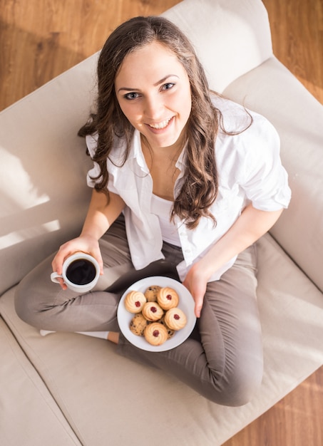 一杯のコーヒーを持つ若い女性の平面図です。