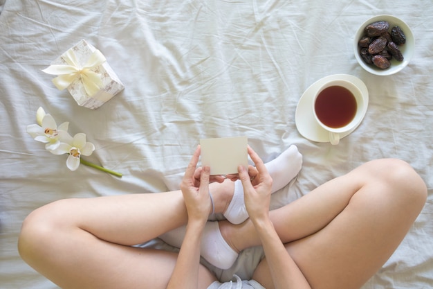 Top view of young woman with present and morning tea