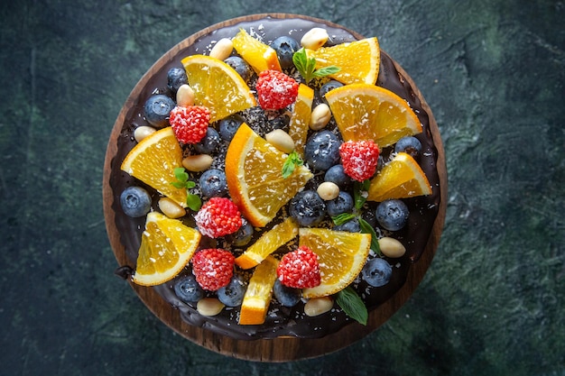 Top view yummy chocolate cake with fresh fruits on dark 