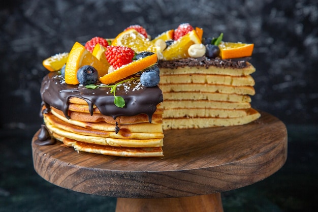 Top view yummy chocolate cake with fruits on dark 