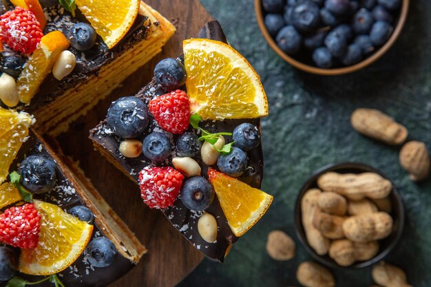 Top view yummy chocolate cake with fruits on dark 