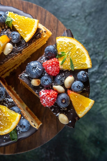 Torta al cioccolato gustosa vista dall'alto con frutta su fondo scuro