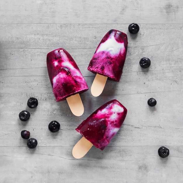 Photo top view of yummy popsicles with blueberries