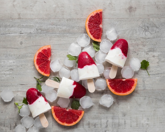 Photo top view of yummy popsicles with red grapefruit