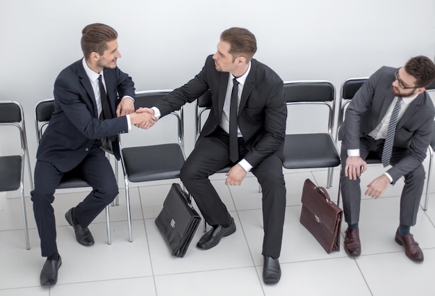 Top viewbusiness colleagues greeting each other with a handshakeoffice weekdays