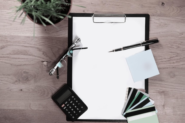 Top viewclipboard with blank sheet pen glasses and calculator